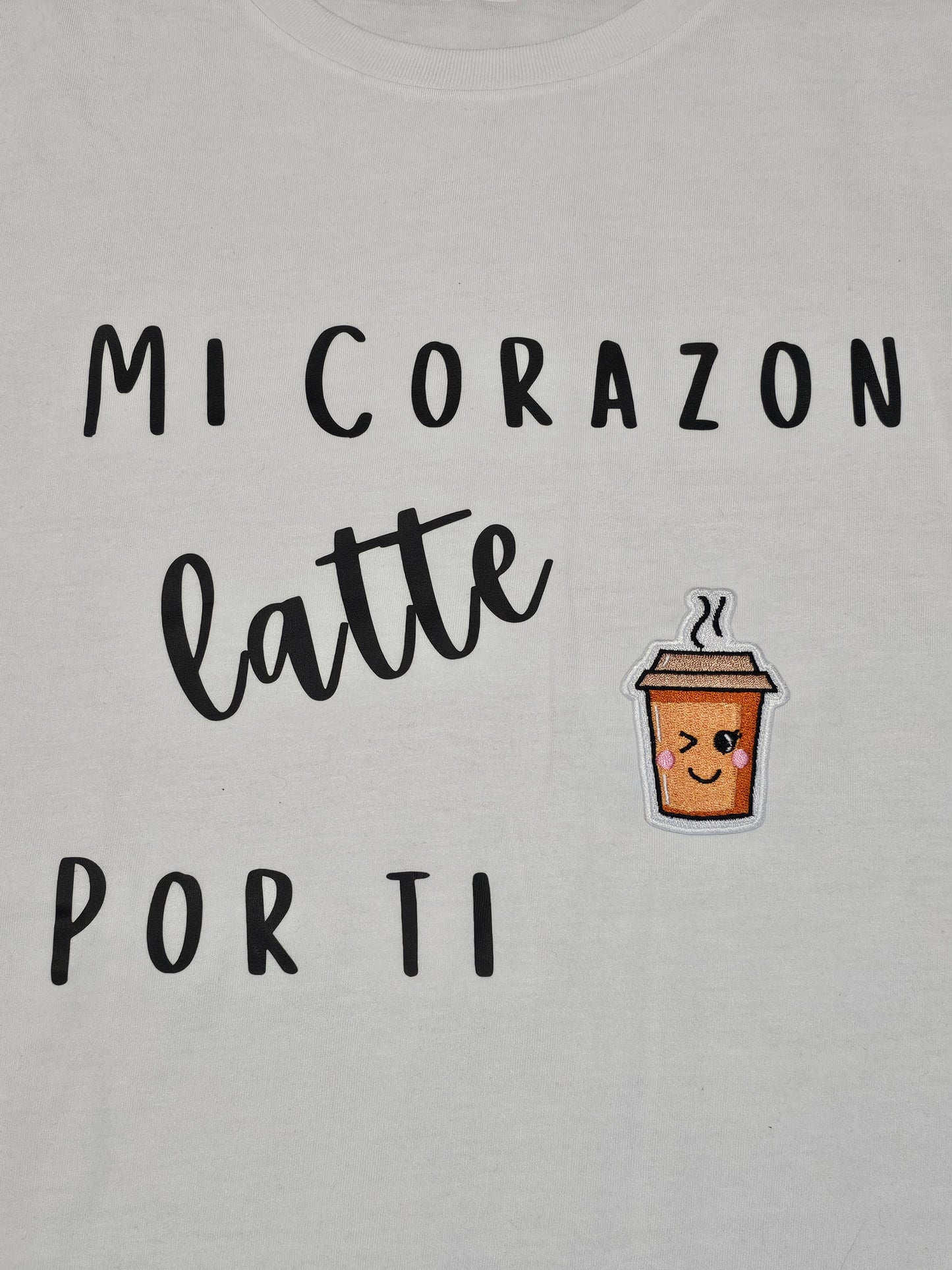'Mi corazon Latte por ti" Short-sleeve, soft syle t-shirt with a cute embroidered coffee cup patch.