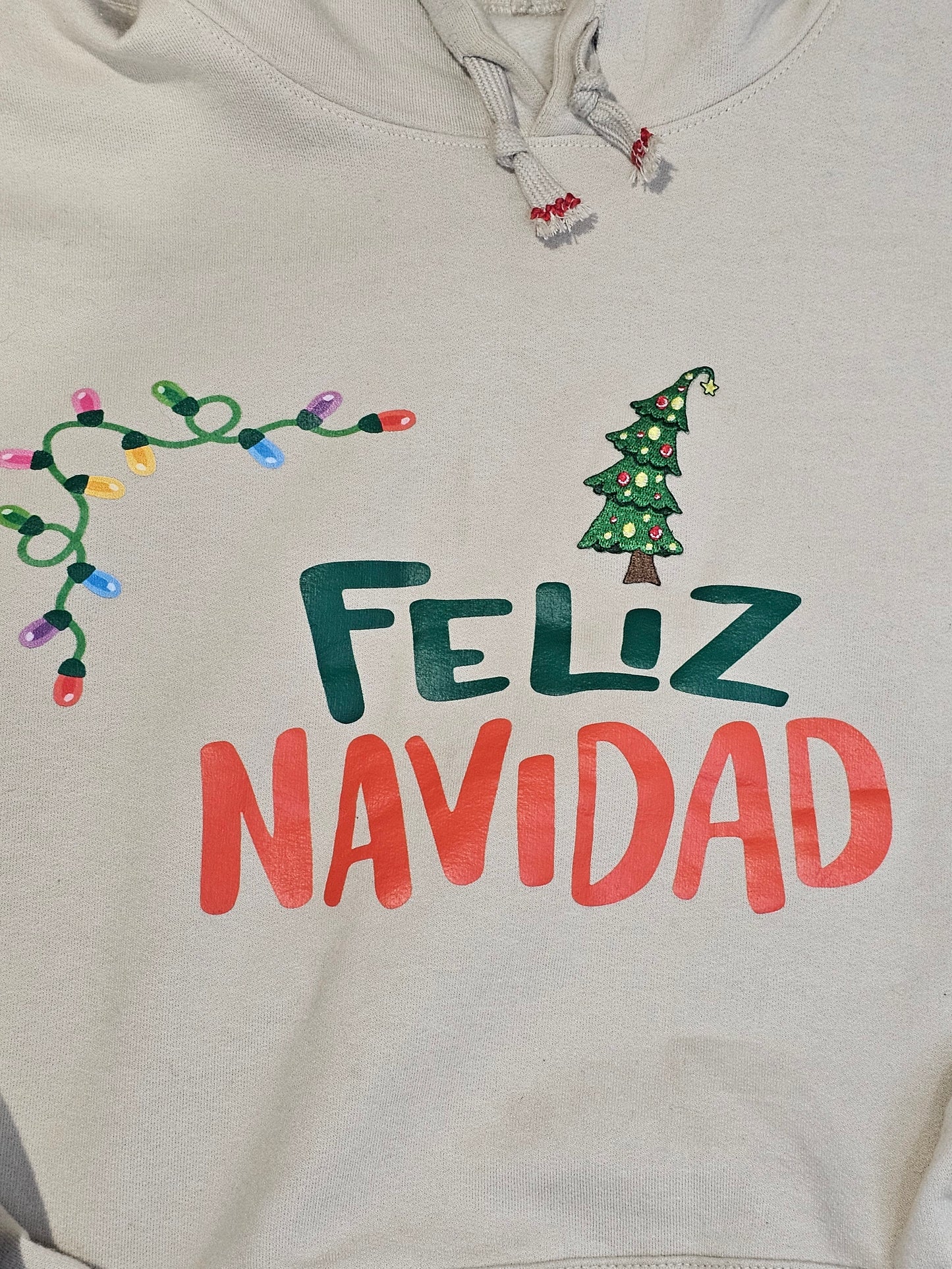 Feliz Navidad Hoodie, soft material featuring an embroidered xmas tree patch is the perfect blend.